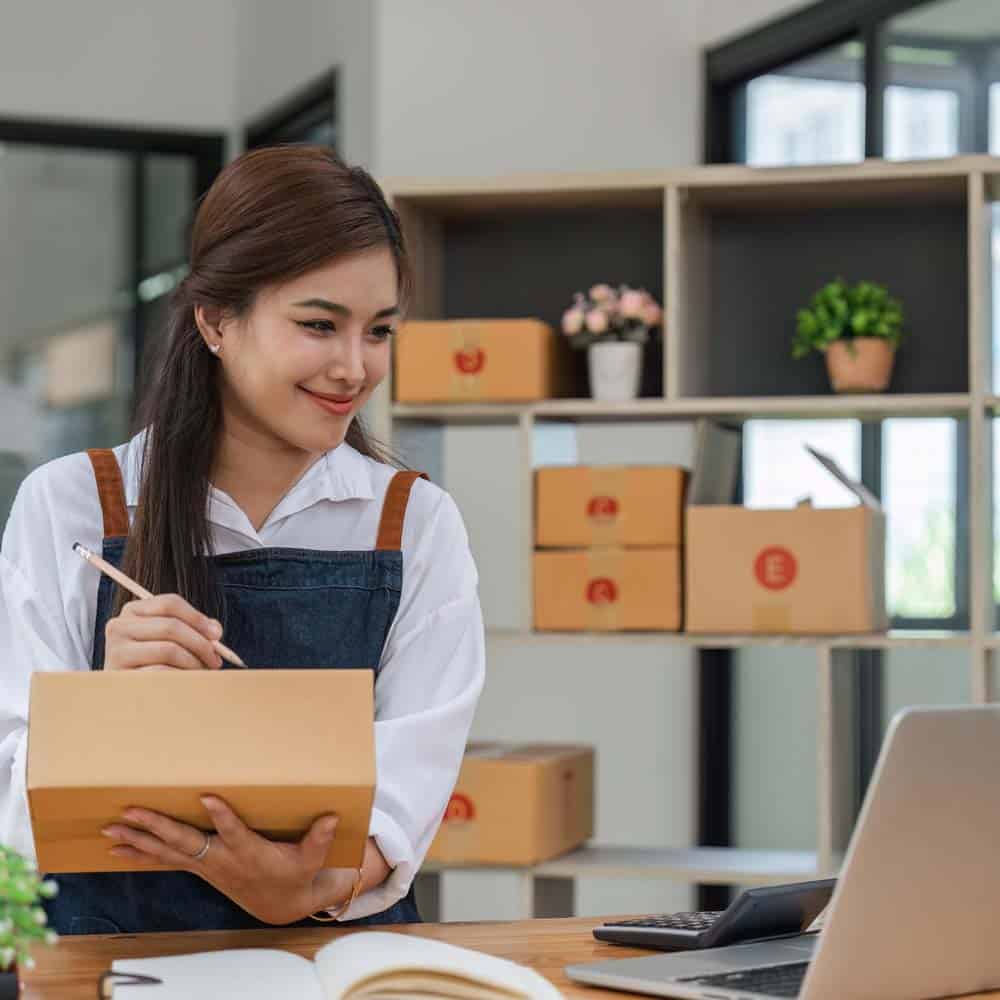 Web Hosting that allows you to get on with your business. Woman fulfilling orders from a laptop.